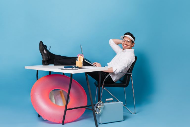 brunette man business suit is working while relaxing with cocktail blue space with suitcase pink rubber ring